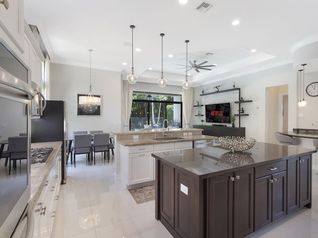 8784 Lewis River Rd, Delray Beach, FL 33446 - kitchen featuring a sink, a large island with sink, a ceiling fan, white cabinetry, and dark stone countertops