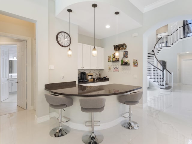 8784 Lewis River Rd, Delray Beach, FL 33446 - kitchen with white cabinetry, a breakfast bar area, baseboards, backsplash, and light tile patterned flooring