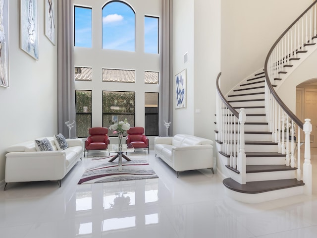 8784 Lewis River Rd, Delray Beach, FL 33446 - living area with a towering ceiling, healthy amount of natural light, stairway, tile patterned flooring, and baseboards