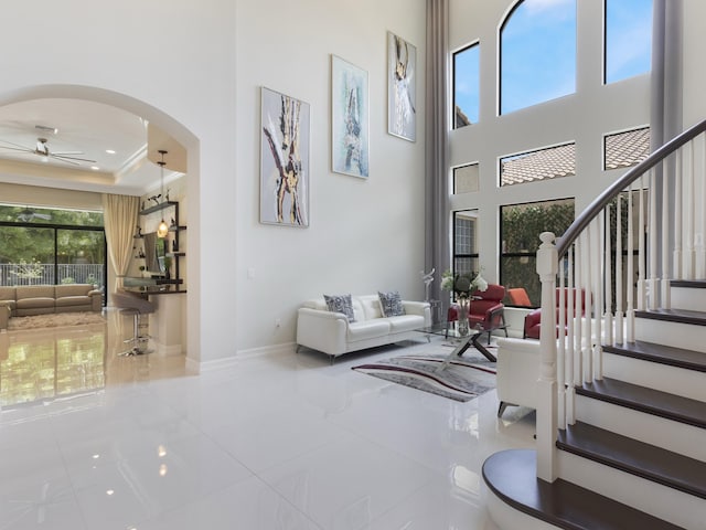 8784 Lewis River Rd, Delray Beach, FL 33446 - tiled entryway with a ceiling fan, arched walkways, baseboards, stairway, and a high ceiling
