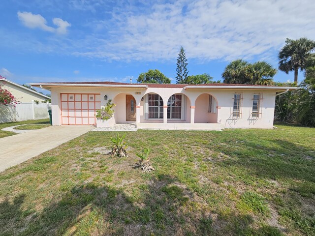 389 SE Tranquilla Ave, Port Saint Lucie, FL 34983 - view of front of house featuring a garage, stucco siding, concrete driveway, and covered porch