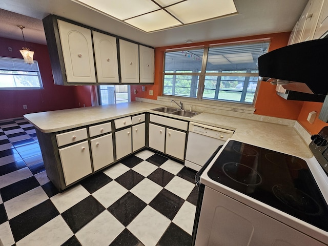 389 SE Tranquilla Ave, Port Saint Lucie, FL 34983 - kitchen featuring white appliances, a sink, light countertops, and a peninsula