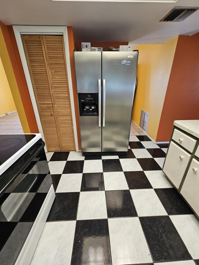 389 SE Tranquilla Ave, Port Saint Lucie, FL 34983 - kitchen featuring stainless steel refrigerator with ice dispenser, electric range, and tile patterned floors