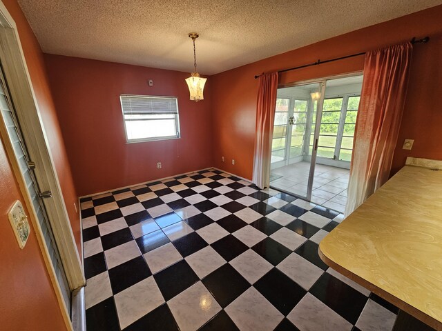 389 SE Tranquilla Ave, Port Saint Lucie, FL 34983 - unfurnished dining area featuring a textured ceiling and a chandelier