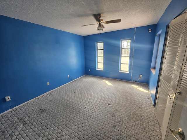 389 SE Tranquilla Ave, Port Saint Lucie, FL 34983 - unfurnished bedroom with carpet flooring, a closet, a textured ceiling, baseboards, and a ceiling fan
