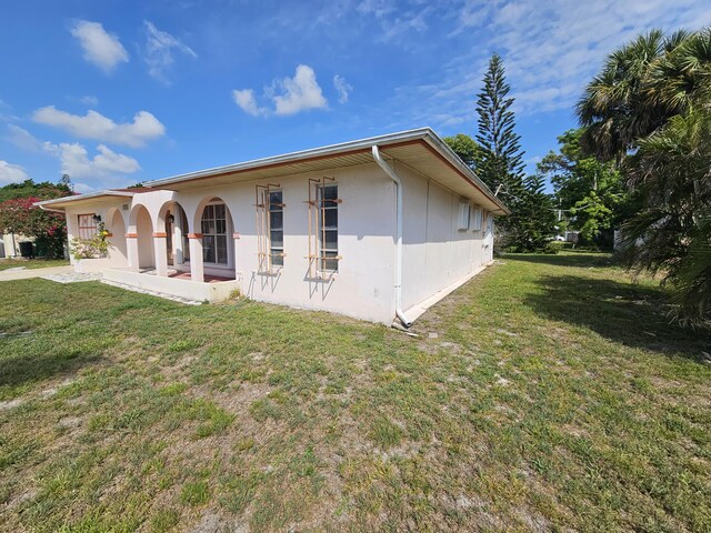 389 SE Tranquilla Ave, Port Saint Lucie, FL 34983 - rear view of property featuring a lawn