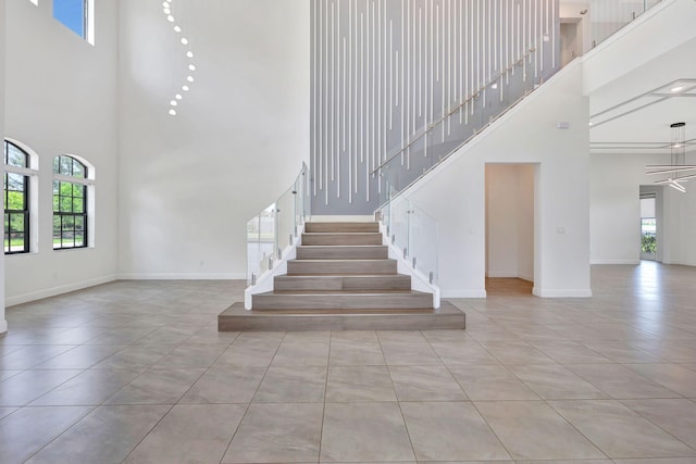 8660 W Parkland Bay Trl, Parkland, FL 33076 - stairway with a towering ceiling, baseboards, and tile patterned flooring
