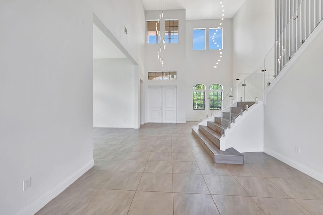 8660 W Parkland Bay Trl, Parkland, FL 33076 - tiled foyer entrance featuring a high ceiling, stairs, and baseboards
