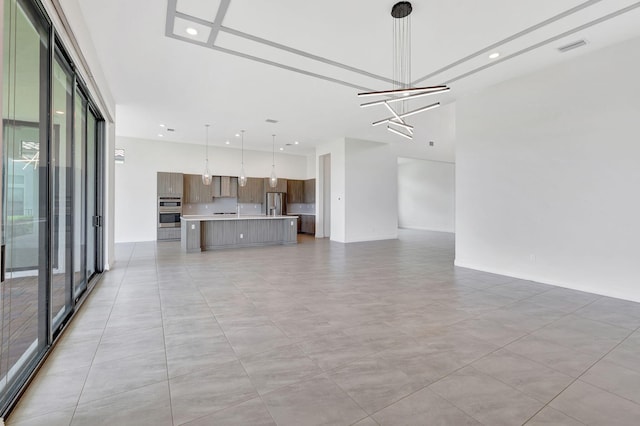 8660 W Parkland Bay Trl, Parkland, FL 33076 - unfurnished living room with a towering ceiling and a chandelier