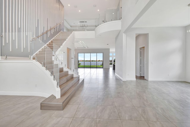8660 W Parkland Bay Trl, Parkland, FL 33076 - stairway featuring a towering ceiling, tile patterned flooring, and baseboards