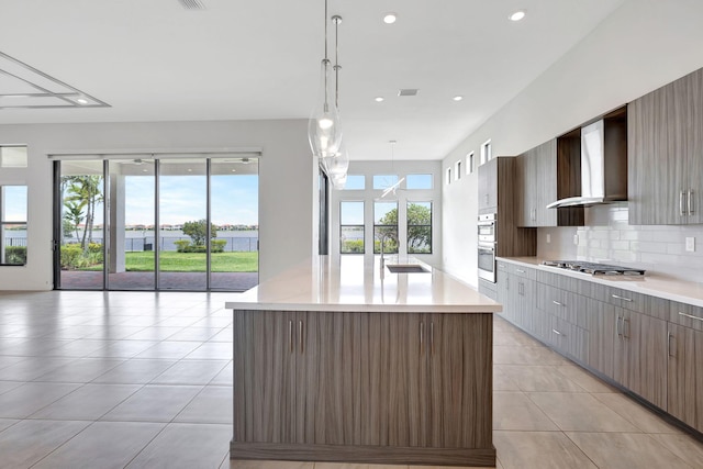 8660 W Parkland Bay Trl, Parkland, FL 33076 - kitchen with a sink, light countertops, wall chimney exhaust hood, appliances with stainless steel finishes, and light tile patterned flooring