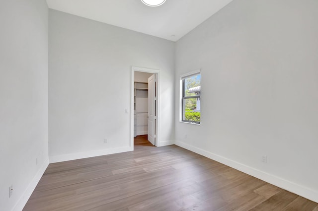 8660 W Parkland Bay Trl, Parkland, FL 33076 - unfurnished bedroom with wood finished floors, baseboards, and a walk in closet