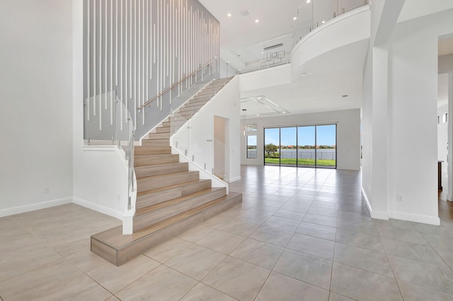 8660 W Parkland Bay Trl, Parkland, FL 33076 - staircase with a towering ceiling, tile patterned flooring, and baseboards