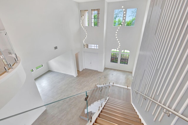 8660 W Parkland Bay Trl, Parkland, FL 33076 - stairway featuring a high ceiling, tile patterned floors, and baseboards