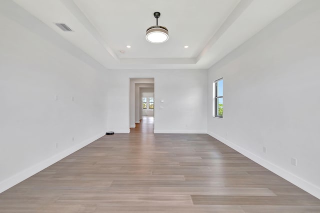 8660 W Parkland Bay Trl, Parkland, FL 33076 - unfurnished room featuring plenty of natural light, a tray ceiling, baseboards, light wood finished floors, and recessed lighting
