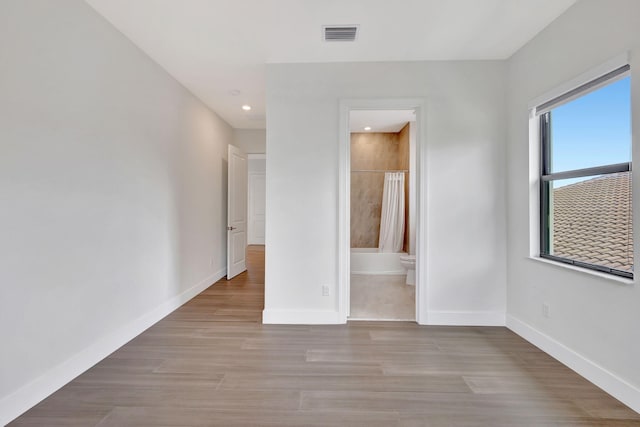 8660 W Parkland Bay Trl, Parkland, FL 33076 - unfurnished bedroom featuring baseboards, light wood-type flooring, connected bathroom, and recessed lighting