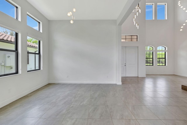 8660 W Parkland Bay Trl, Parkland, FL 33076 - spare room with a high ceiling, baseboards, and light tile patterned flooring