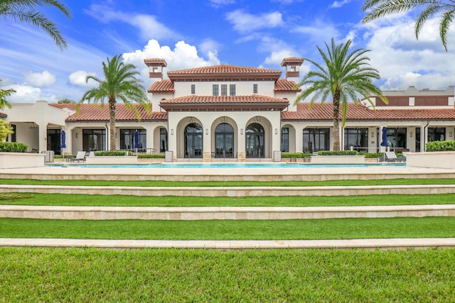 8660 W Parkland Bay Trl, Parkland, FL 33076 - rear view of house featuring a tiled roof, stucco siding, a lawn, and an outdoor pool