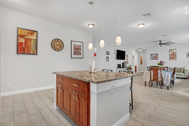309 NE 11th Ave, Boynton Beach, FL 33435 - kitchen featuring ceiling fan, a kitchen island, open floor plan, baseboards, and hanging light fixtures