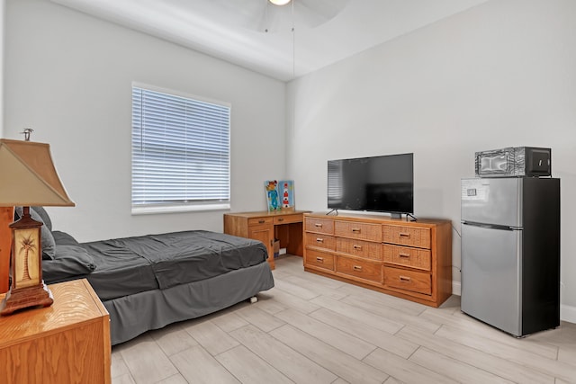 309 NE 11th Ave, Boynton Beach, FL 33435 - bedroom featuring freestanding refrigerator, wood finish floors, and a ceiling fan