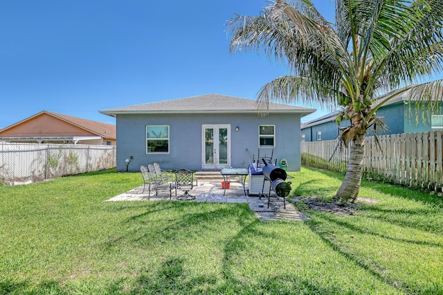 309 NE 11th Ave, Boynton Beach, FL 33435 - back of property with french doors, stucco siding, and a patio area