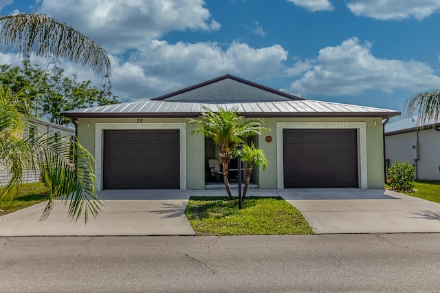 29 Mediterranean Blvd W, Port Saint Lucie, FL 34952 - ranch-style house featuring a standing seam roof, concrete driveway, stucco siding, and an attached garage