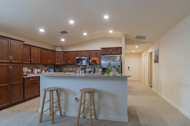 29 Mediterranean Blvd W, Port Saint Lucie, FL 34952 - kitchen featuring stainless steel appliances, a breakfast bar area, backsplash, vaulted ceiling, and recessed lighting