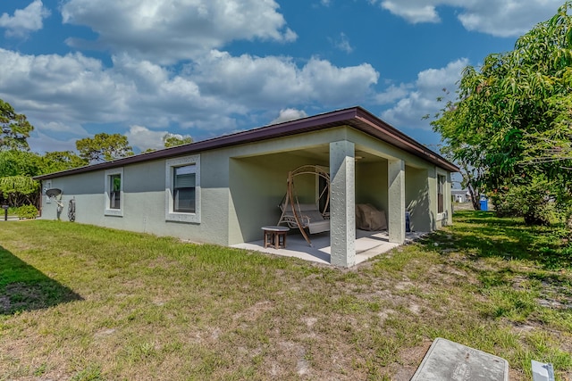 29 Mediterranean Blvd W, Port Saint Lucie, FL 34952 - back of property with a patio area, stucco siding, a yard, and an attached carport