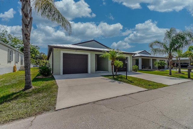 29 Mediterranean Blvd W, Port Saint Lucie, FL 34952 - ranch-style home with a garage, a front lawn, concrete driveway, stucco siding, and a standing seam roof