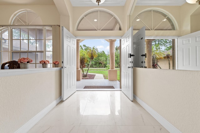 6839 Banyan Blvd, The Acreage, FL 33470 - entryway featuring marble tiled floors, decorative columns, plenty of natural light, baseboards, and a textured wall