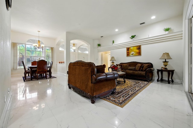 6839 Banyan Blvd, The Acreage, FL 33470 - living room featuring a chandelier, arched walkways, marble finish flooring, healthy amount of natural light, and recessed lighting