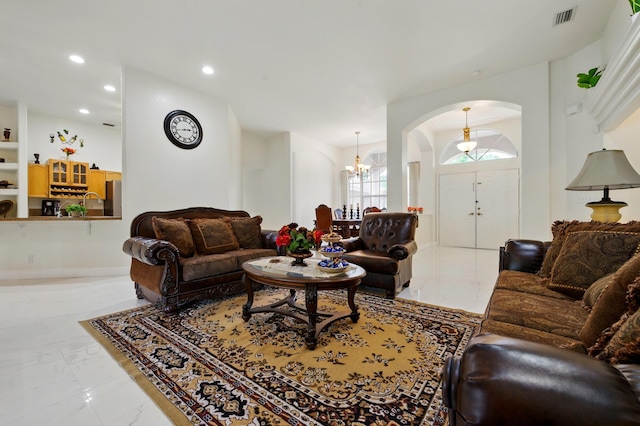 6839 Banyan Blvd, The Acreage, FL 33470 - living area featuring arched walkways, a chandelier, light marble finish flooring, and recessed lighting