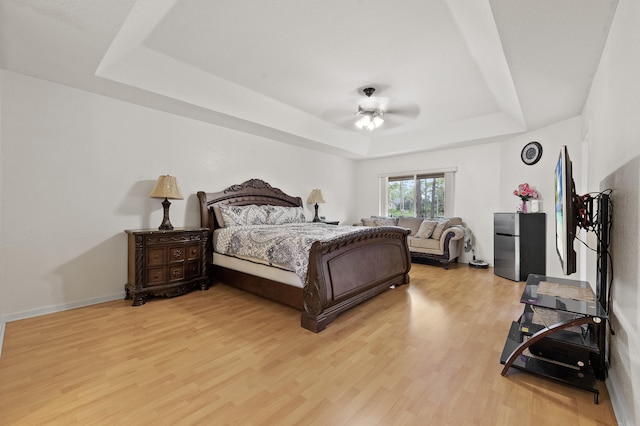 6839 Banyan Blvd, The Acreage, FL 33470 - bedroom featuring a raised ceiling, light wood-style floors, a ceiling fan, and baseboards