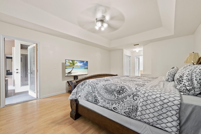 6839 Banyan Blvd, The Acreage, FL 33470 - bedroom featuring a raised ceiling, light wood-style floors, baseboards, ceiling fan, and ensuite bathroom