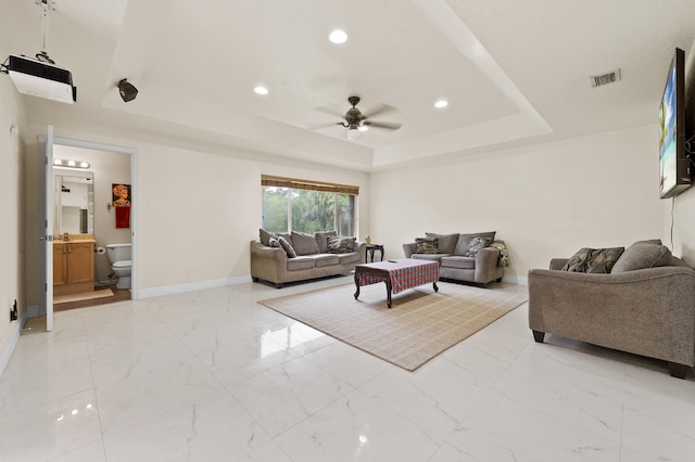 6839 Banyan Blvd, The Acreage, FL 33470 - living room featuring a raised ceiling, ceiling fan, baseboards, light marble finish flooring, and recessed lighting