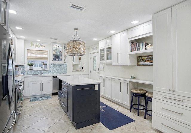 1177 Bayshore Dr Unit 207, Fort Pierce, FL 34949 - kitchen featuring white cabinetry, light tile patterned floors, light countertops, a sink, and glass insert cabinets