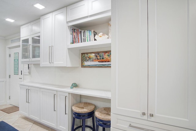 1177 Bayshore Dr Unit 207, Fort Pierce, FL 34949 - kitchen featuring white cabinetry, light countertops, open shelves, light tile patterned flooring, and a kitchen breakfast bar