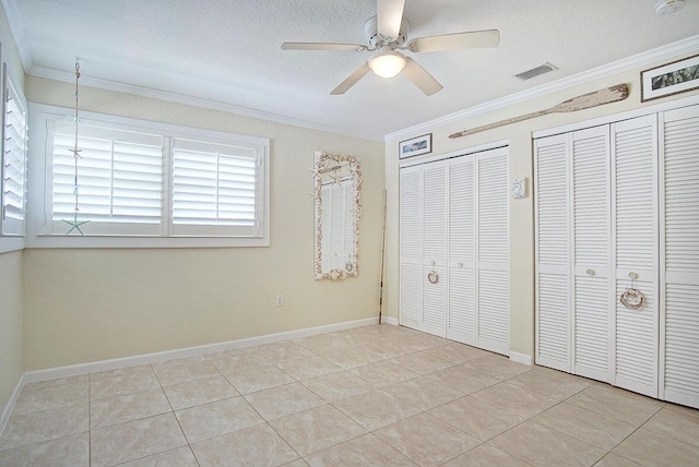 1177 Bayshore Dr Unit 207, Fort Pierce, FL 34949 - unfurnished bedroom with crown molding, two closets, tile patterned flooring, a ceiling fan, and baseboards