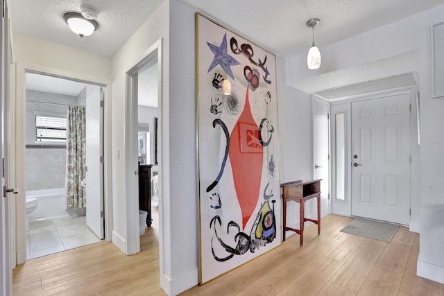 2850 Carambola Cir S Unit 19121, Coconut Creek, FL 33066 - entrance foyer featuring light wood-style flooring, a textured ceiling, and baseboards