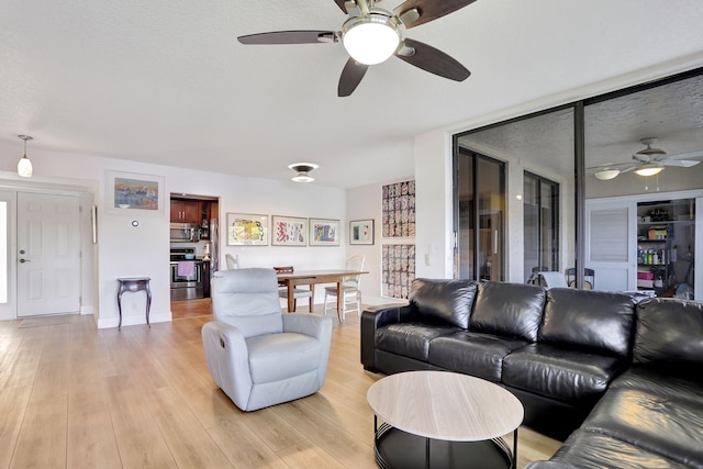 2850 Carambola Cir S Unit 19121, Coconut Creek, FL 33066 - living room featuring ceiling fan, light wood finished floors, and baseboards