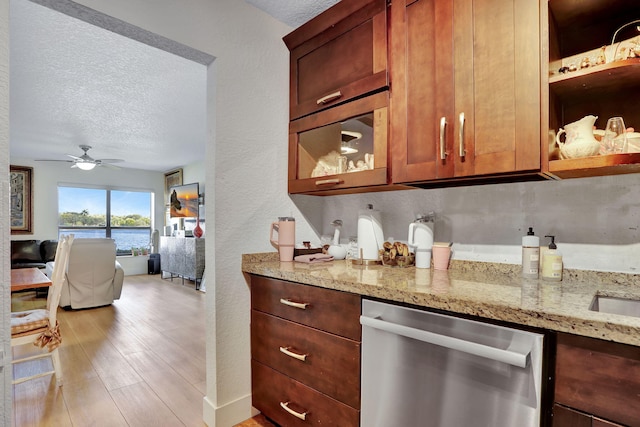 2850 Carambola Cir S Unit 19121, Coconut Creek, FL 33066 - kitchen featuring stainless steel dishwasher, a textured wall, a textured ceiling, light stone counters, and ceiling fan