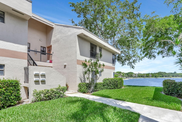 2850 Carambola Cir S Unit 19121, Coconut Creek, FL 33066 - view of property exterior featuring stucco siding, a water view, a lawn, and a balcony