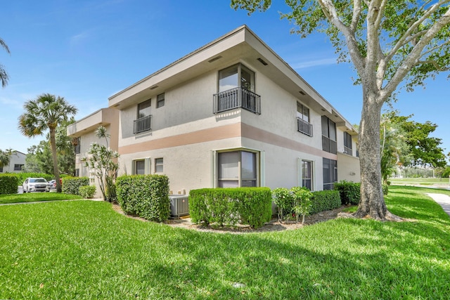 2850 Carambola Cir S Unit 19121, Coconut Creek, FL 33066 - view of home's exterior with stucco siding, a yard, a balcony, and cooling unit