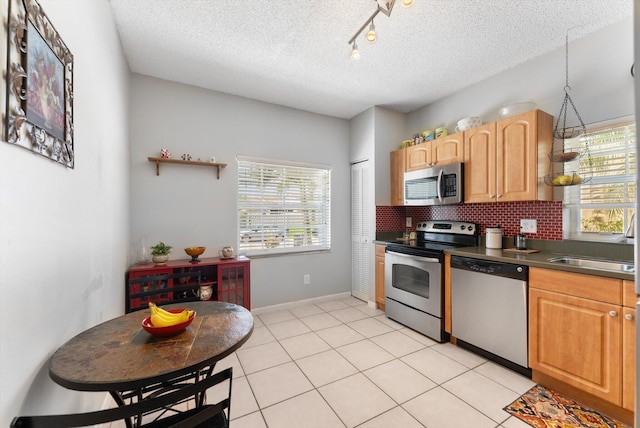 7930 Nolting Ct, Lake Worth, FL 33467 - kitchen with stainless steel appliances, a textured ceiling, dark countertops, backsplash, and baseboards