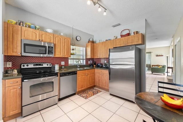 7930 Nolting Ct, Lake Worth, FL 33467 - kitchen featuring stainless steel appliances, dark countertops, backsplash, a textured ceiling, and light tile patterned floors