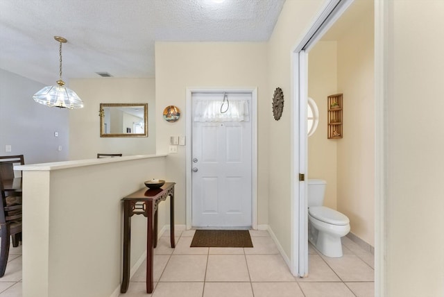 7930 Nolting Ct, Lake Worth, FL 33467 - foyer entrance with light tile patterned floors, a textured ceiling, and baseboards