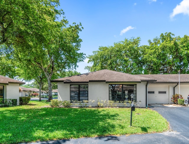 4731 Storkwood Ln Unit A, Boynton Beach, FL 33436 - view of front facade with stucco siding, an attached garage, driveway, and a front yard