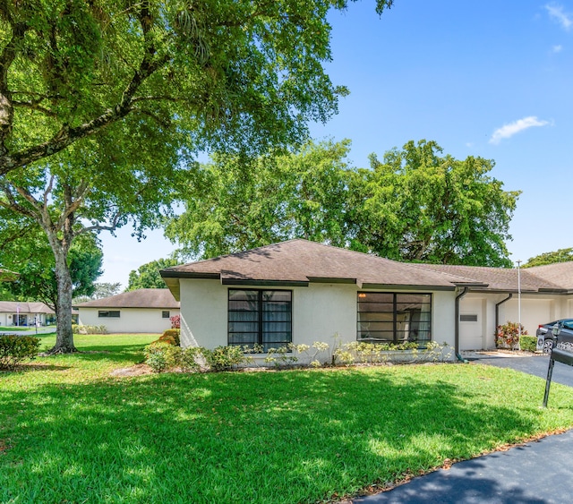 4731 Storkwood Ln Unit A, Boynton Beach, FL 33436 - view of front facade with stucco siding, a front yard, and asphalt driveway