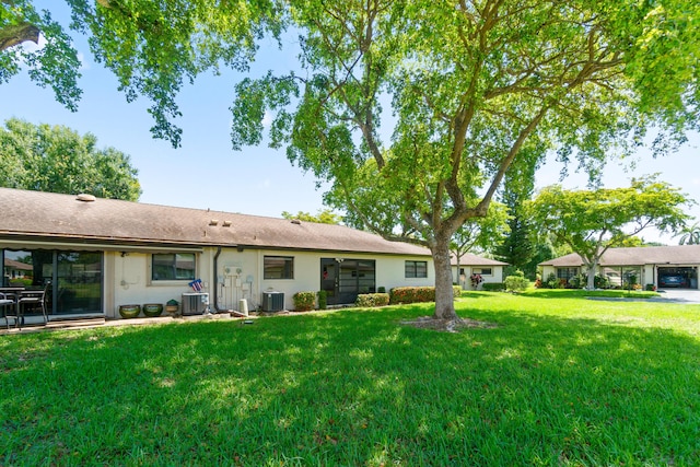 4731 Storkwood Ln Unit A, Boynton Beach, FL 33436 - rear view of property with cooling unit, a yard, stucco siding, and a shingled roof