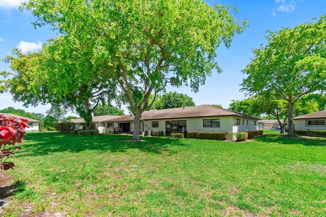 4731 Storkwood Ln Unit A, Boynton Beach, FL 33436 - rear view of property with a lawn and stucco siding